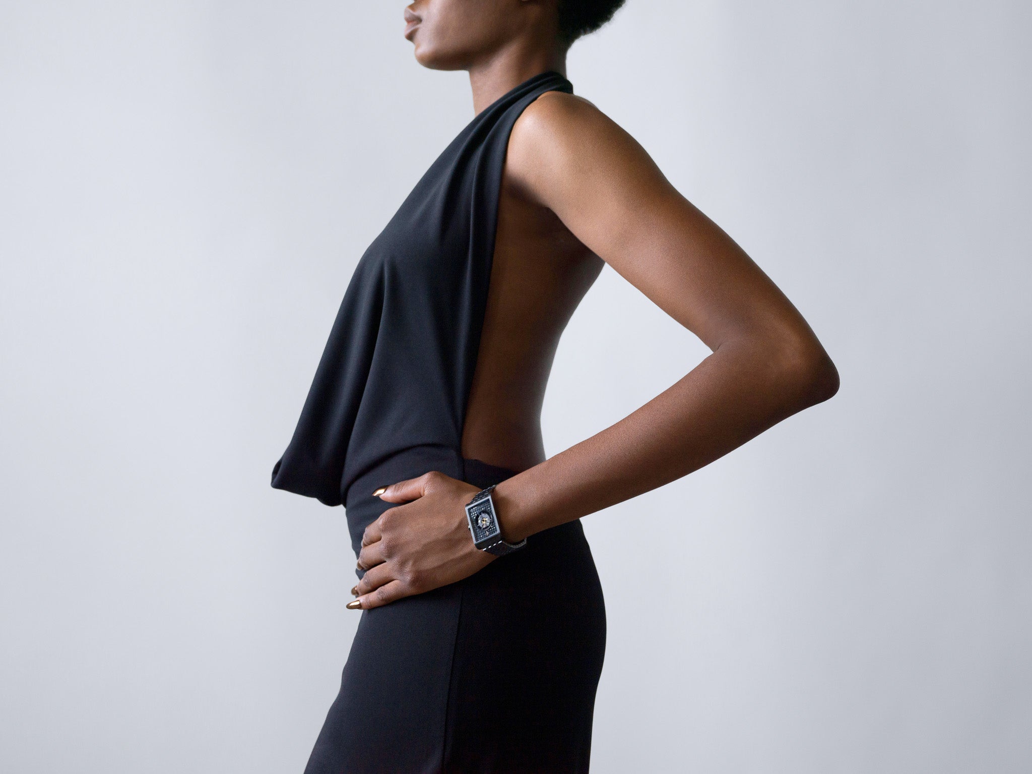 Side profile of a woman in a backless black dress wearing a bold square-face Vieren watch, photographed by Toronto-based commercial photographer Nicholas Hyatt. The minimalist styling emphasizes contemporary fashion and luxury timepiece design.